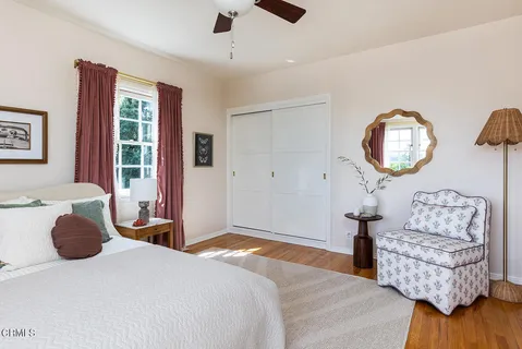 a bedroom with furniture and a large window