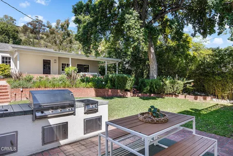 a view of house with backyard outdoor seating and green space