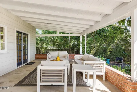 a outdoor space with the couches and dining table with the garden view