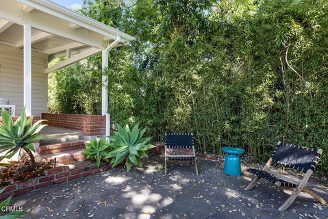 a view of a chair and table in backyard of the house