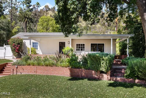 a front view of house with a yard and potted plants