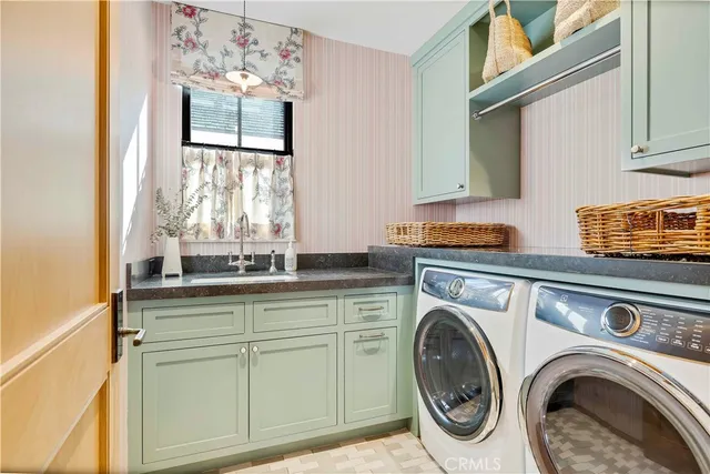 a utility room with sink dryer and washer