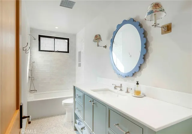 a bathroom with a sink a toilet and a mirror