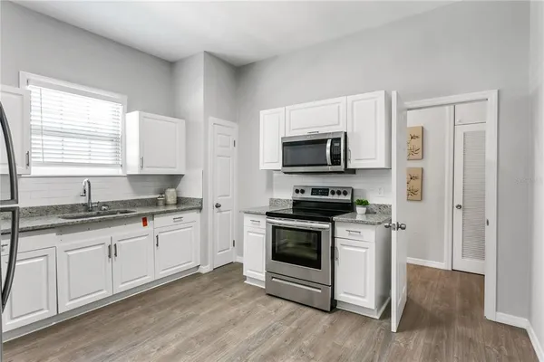a kitchen with stainless steel appliances a stove microwave and sink