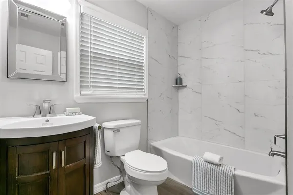 a bathroom with a sink toilet vanity and tub