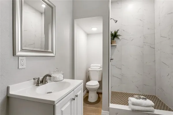 a bathroom with a sink a toilet and shower