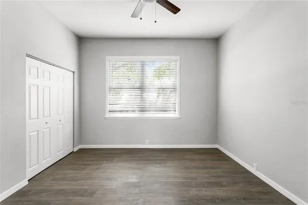 an empty room with a window and a ceiling fan