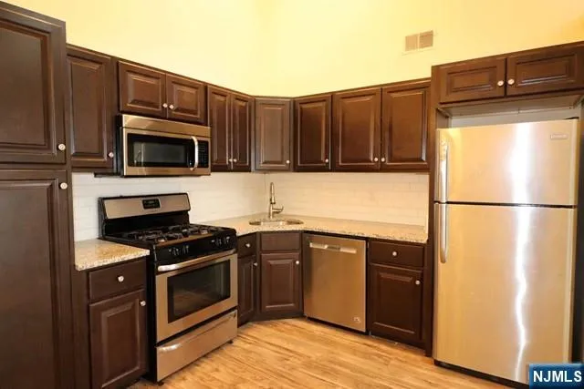 a kitchen with granite countertop a stove top oven and cabinets