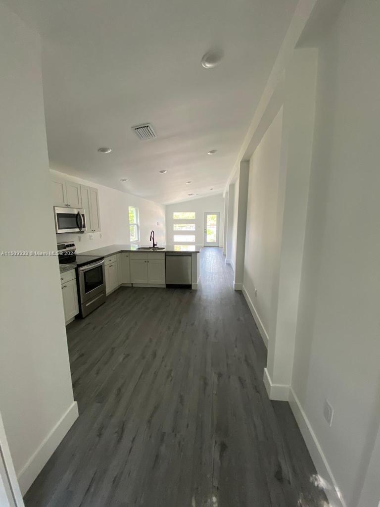 190 Northwest 57th Street Miami, FL 33127 - Photo 8 of 11 a living room with stainless steel appliances furniture a refrigerator and wooden floor