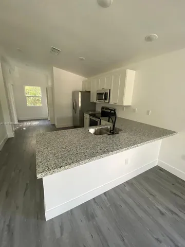 a view of kitchen with granite countertop sink and natural light