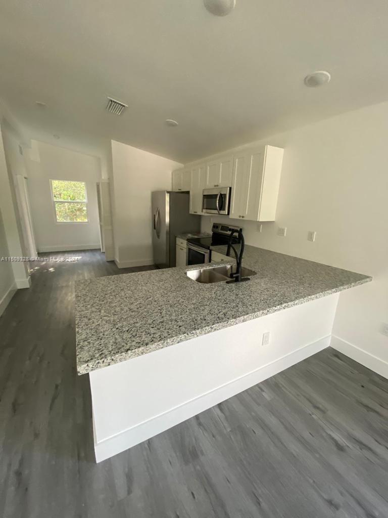 190 Northwest 57th Street Miami, FL 33127 - Photo 9 of 11 a view of kitchen with granite countertop sink and natural light