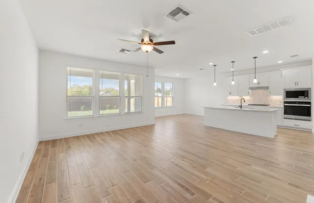 a kitchen with a sink appliances and cabinets