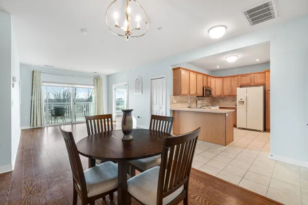 a view of a dining room with furniture a chandelier and wooden floor