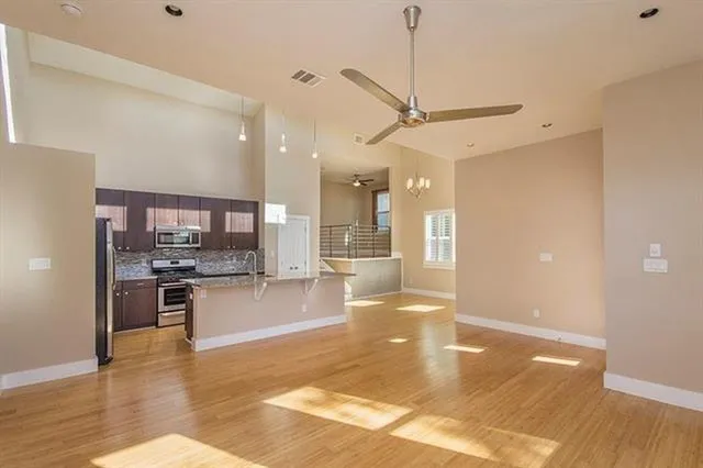 a large kitchen with stainless steel appliances a large counter top a stove and a refrigerator