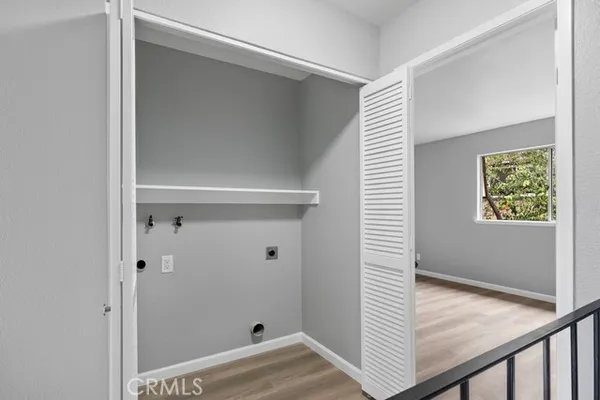 a view of a hallway with wooden floor and closet