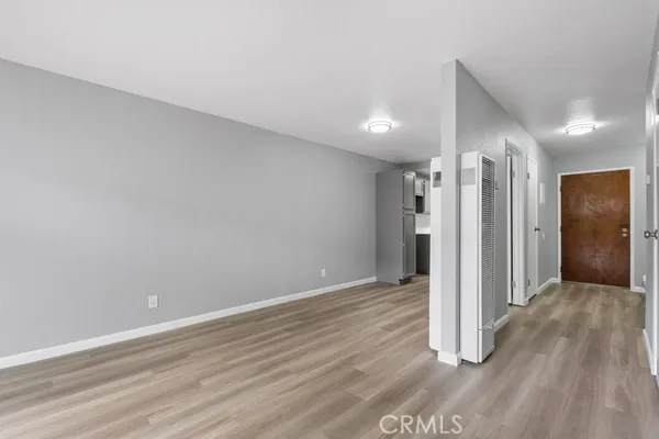 a view of an empty room with wooden floor