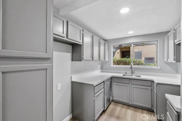 a kitchen with a sink dishwasher a stove and cabinets