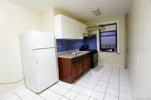 a kitchen with a refrigerator a stove top oven and cabinets
