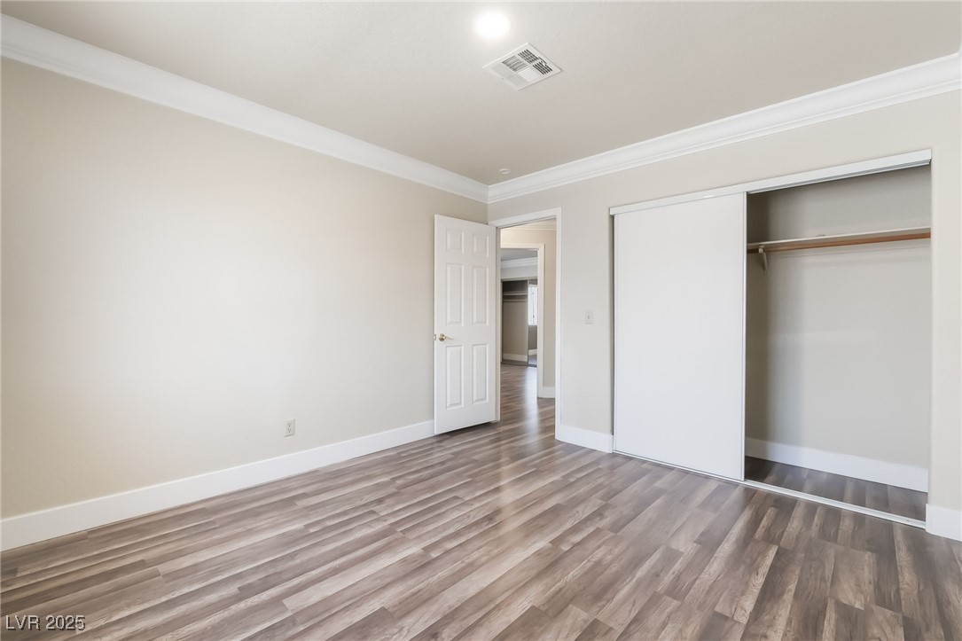 1804 Michaels Court Henderson, NV 89014 - Photo 27 of 44 Unfurnished bedroom featuring crown molding, wood finished floors, and a closet