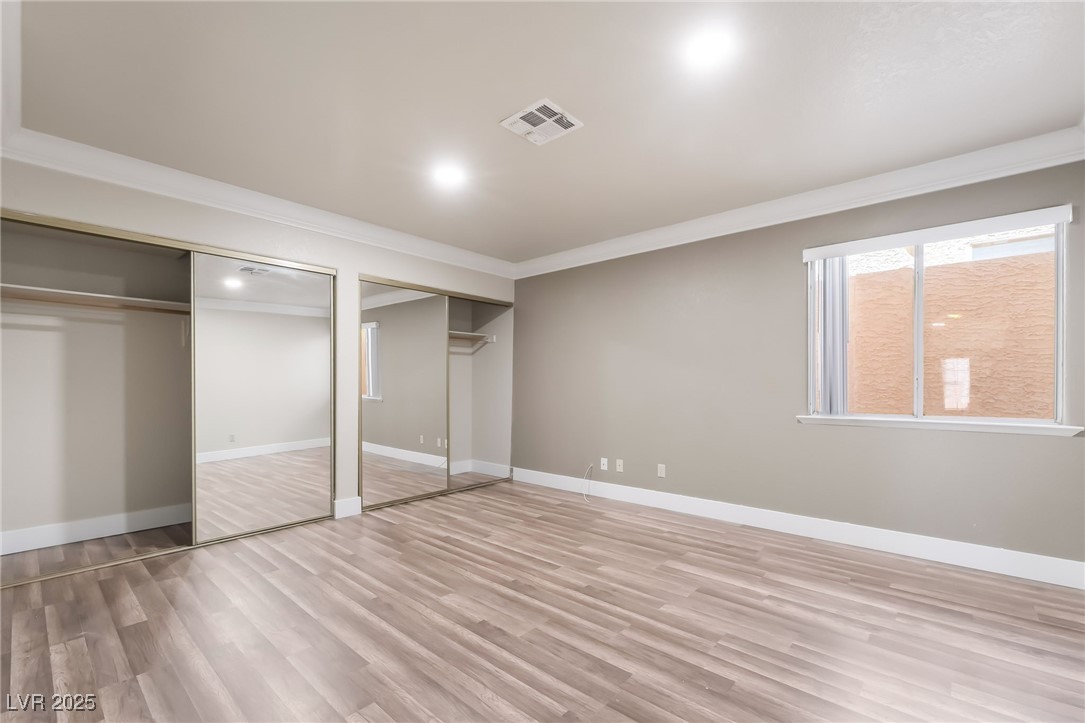 1804 Michaels Court Henderson, NV 89014 - Photo 31 of 44 Unfurnished bedroom featuring two closets, crown molding, and wood finished floors