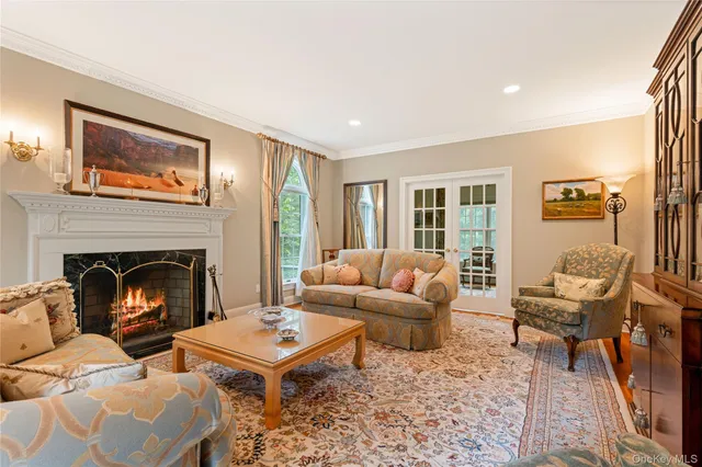 an empty room with wooden floor fireplace and windows