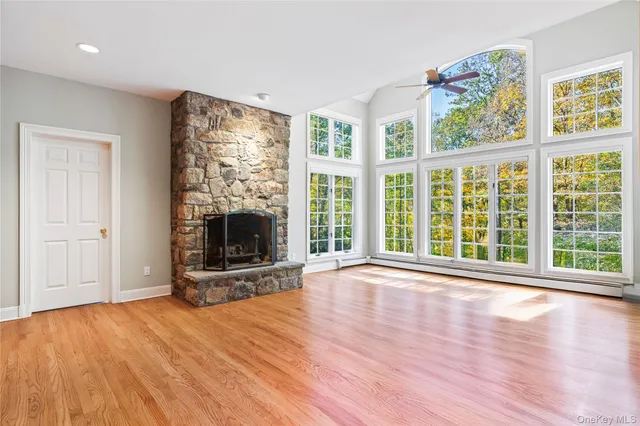 a living room with furniture a fireplace and a floor to ceiling window