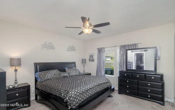 a bedroom with a bed and a dresser with mirror