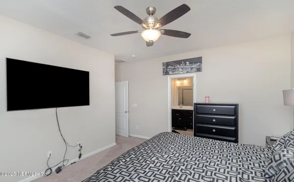 a room with a flat screen tv and dresser