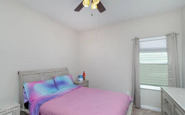 a bedroom with a bed and a chandelier fan