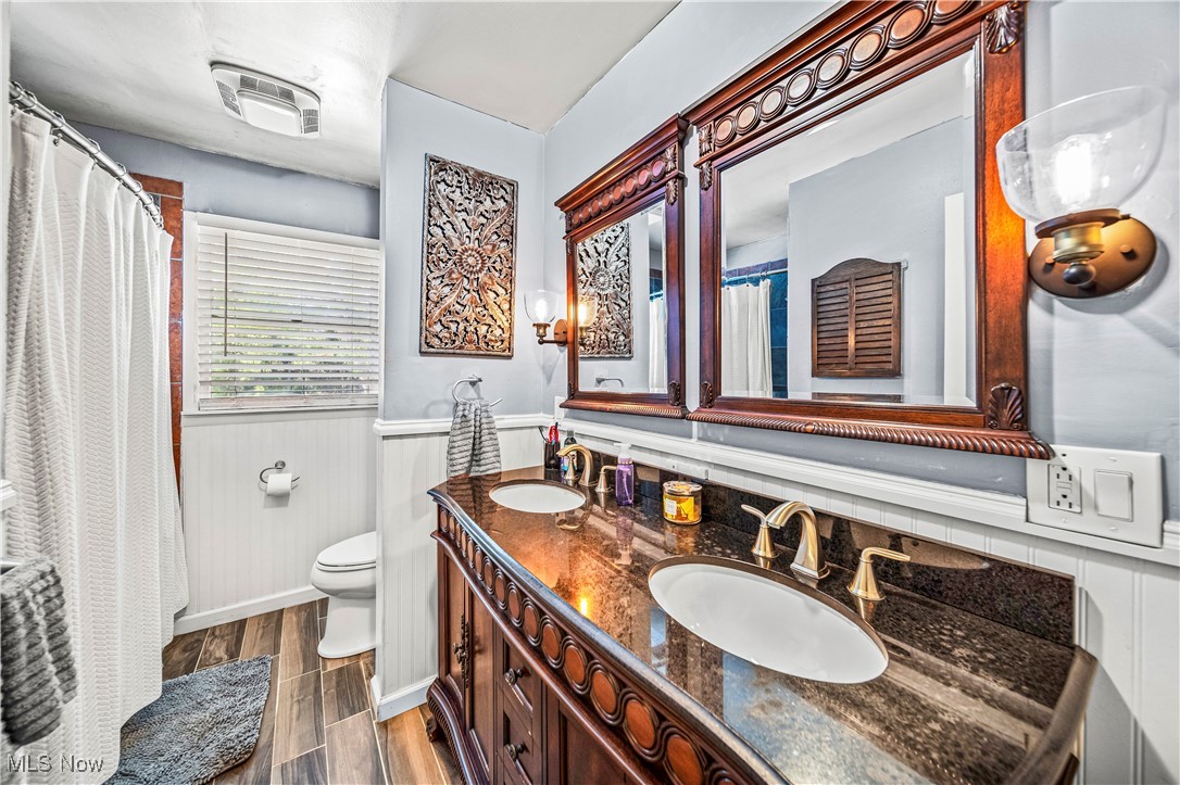 6981 Howard Road Williamsfield, OH 44093 - Photo 13 of 42 Bathroom featuring hardwood / wood-style floors, toilet, vanity, and backsplash