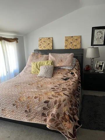 a large bed sitting in a bedroom next to a window