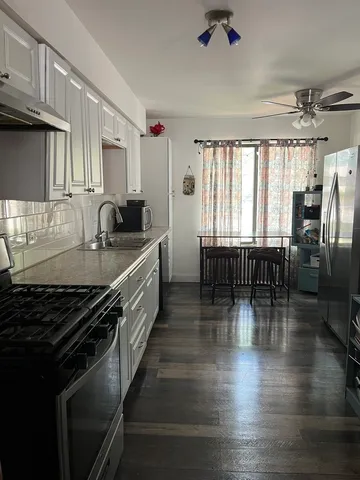 a kitchen with granite countertop a stove and a wooden floors