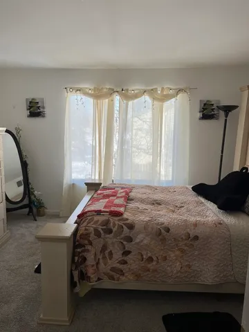 a bedroom with a bed a mirror and a window