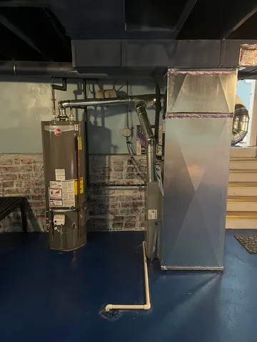 a room with water heater and wooden floor