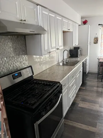 a kitchen with granite countertop a stove and a sink