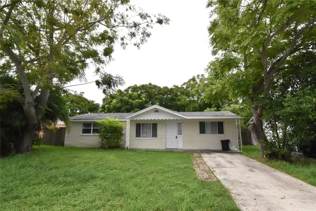 a view of a house with a yard and large tree