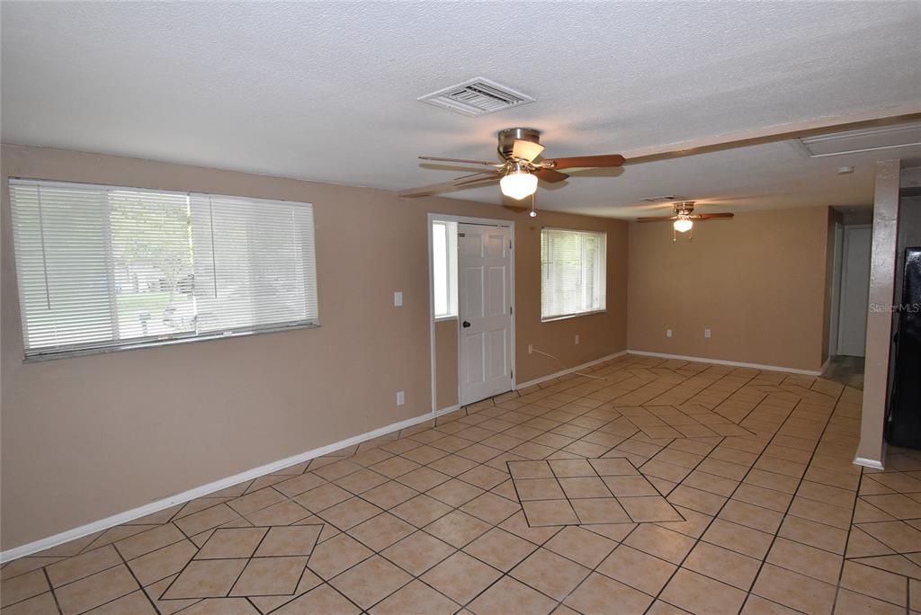 7524 Galahad Road Port Richey, FL 34668 - Photo 2 of 26 a view of an empty room with window and chandelier fan