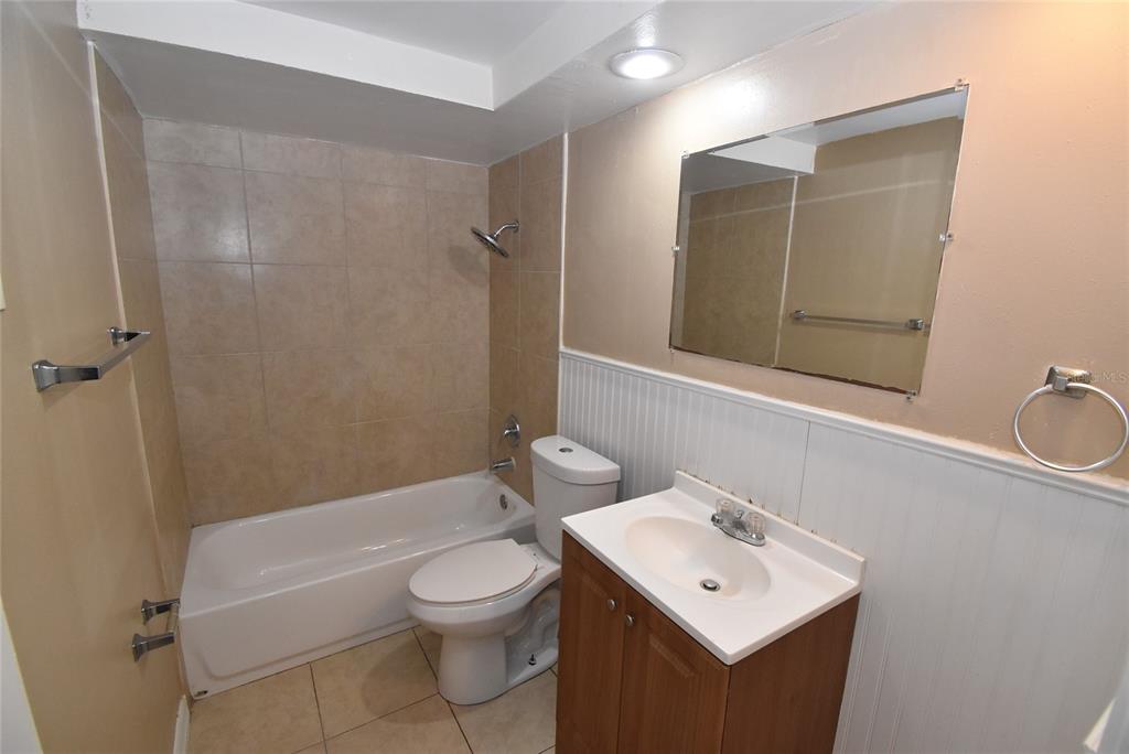 7524 Galahad Road Port Richey, FL 34668 - Photo 21 of 26 a bathroom with a toilet a sink a mirror a bathtub and shower