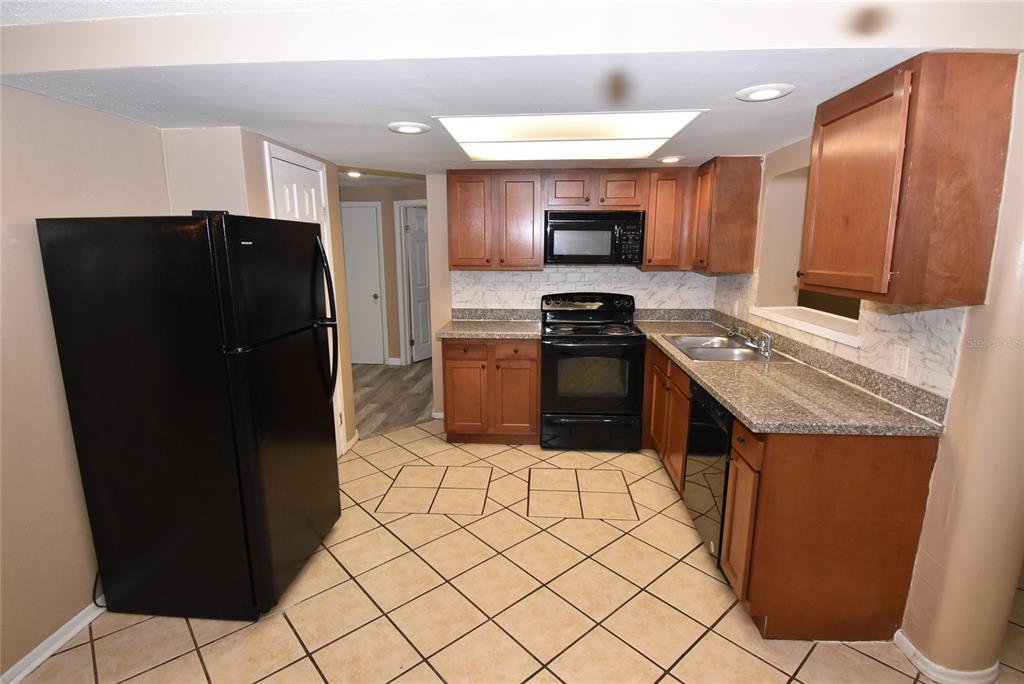 7524 Galahad Road Port Richey, FL 34668 - Photo 7 of 26 a kitchen with stainless steel appliances granite countertop a refrigerator and a stove