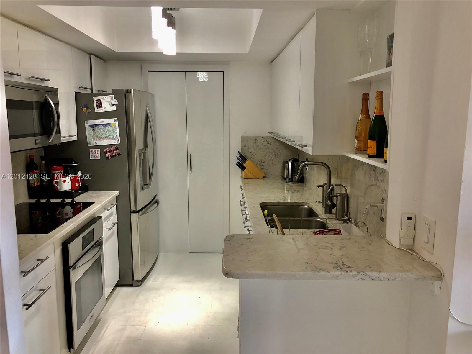 90 Alton Road, Unit 307 Miami Beach, FL 33139 - Photo 4 of 11 a kitchen with stainless steel appliances granite countertop a sink stove and refrigerator