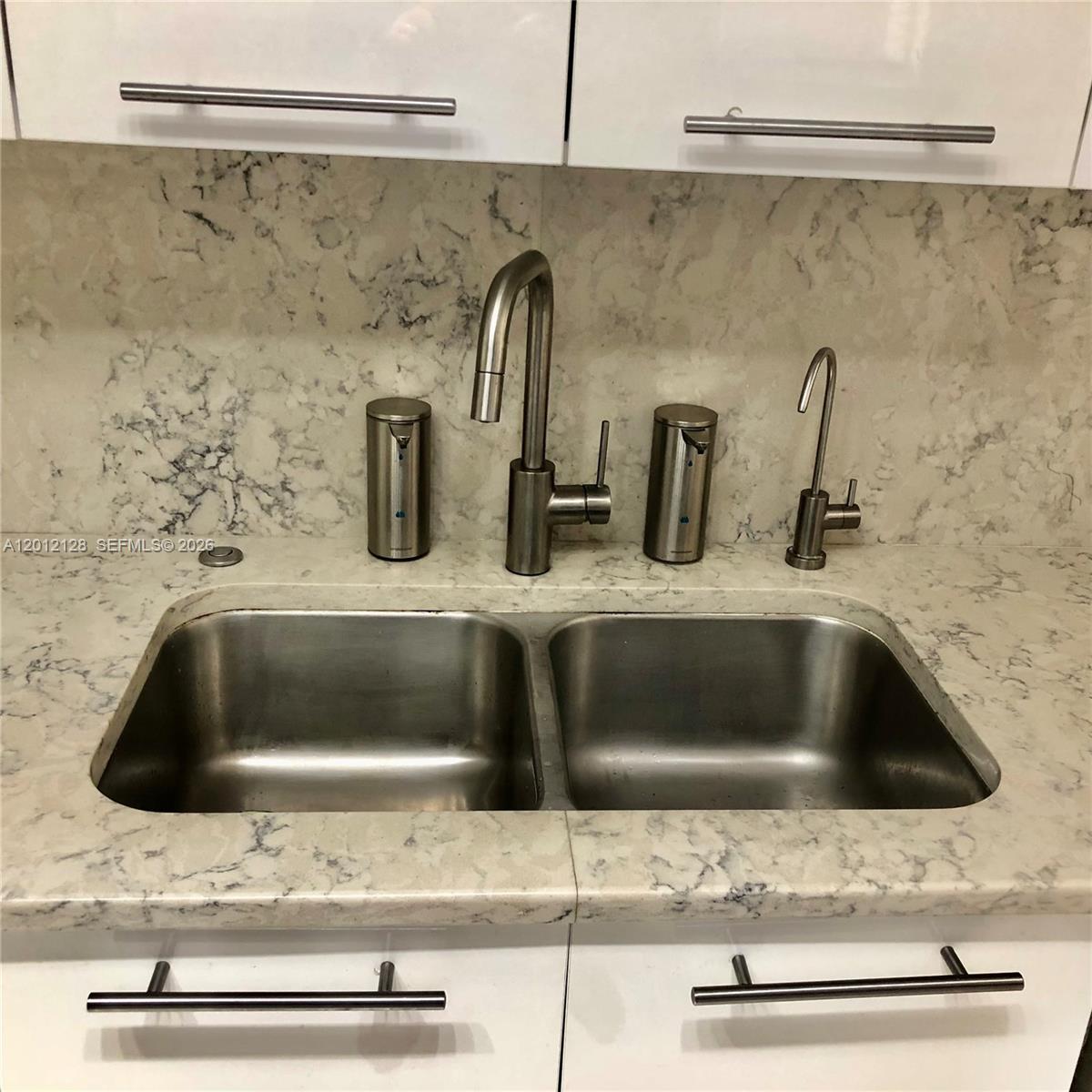 90 Alton Road, Unit 307 Miami Beach, FL 33139 - Photo 5 of 11 a kitchen sink with a stove and cabinets