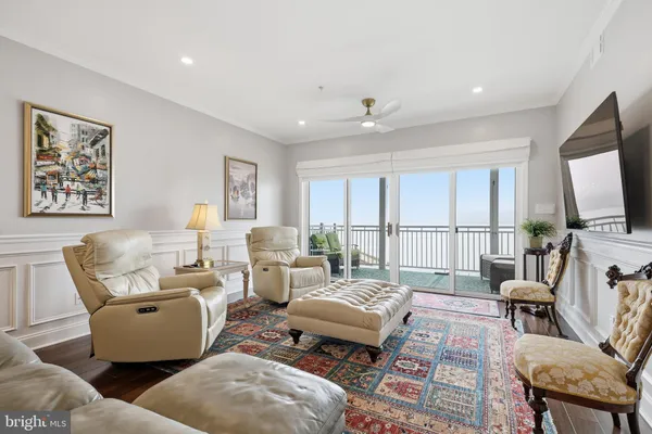 a living room with furniture a large window and a flat screen tv