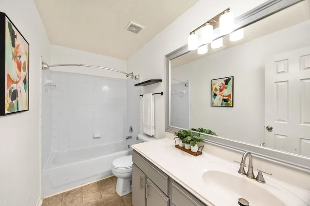 a bathroom with a granite countertop sink a toilet and shower