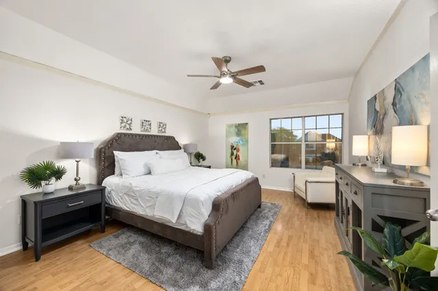 a bedroom with a bed and large window with view of balcony