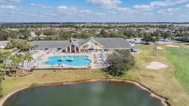 an aerial view of residential house with outdoor space and trees all around