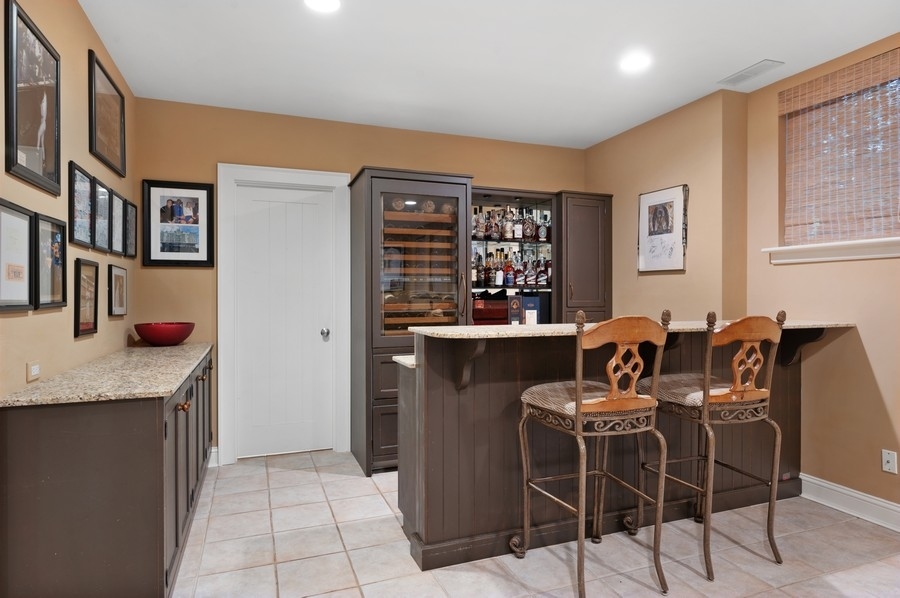 501 Ridge Road Kenilworth, IL 60043 - Photo 33 of 46 a kitchen with stainless steel appliances granite countertop a table chairs and a refrigerator