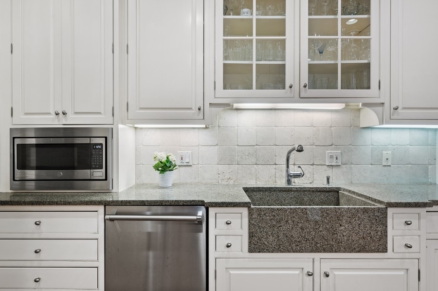 501 Ridge Road Kenilworth, IL 60043 - Photo 9 of 46 a kitchen with stainless steel appliances granite countertop white cabinets and a sink