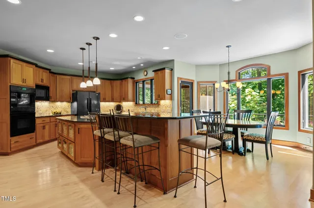 a view of big room with wooden floor chandeliers and kitchen view