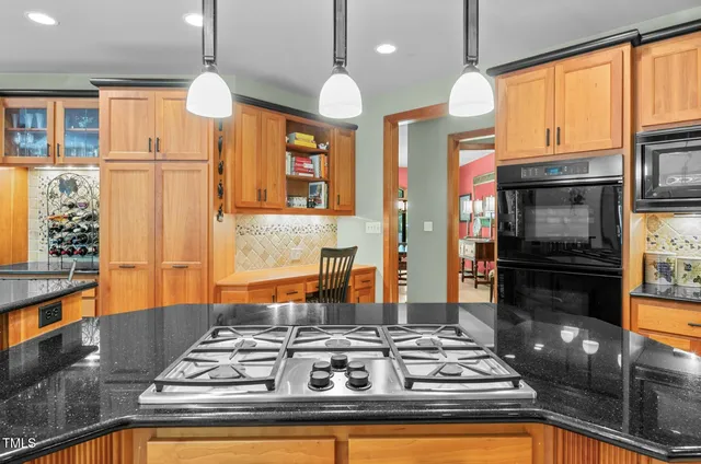 a view of an empty room with a window and a kitchen