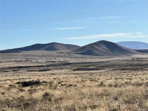 a view of a dry yard with wooden floor and a mountain view